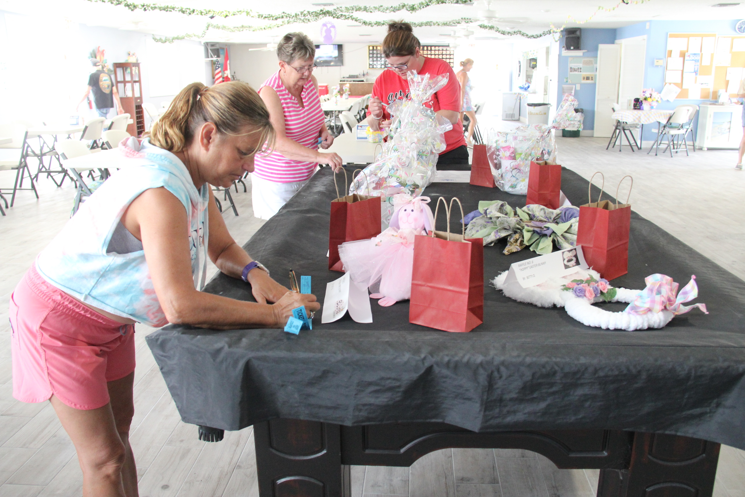 Jannette Burt and Sharon Anderson get their tickets in the bags for the Chinese Auction before helping with the games. 